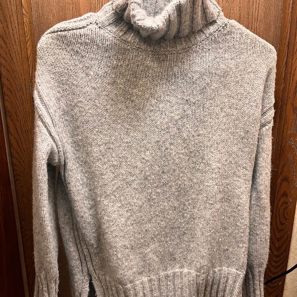 oversized turtleneck sweater in a light gray color.